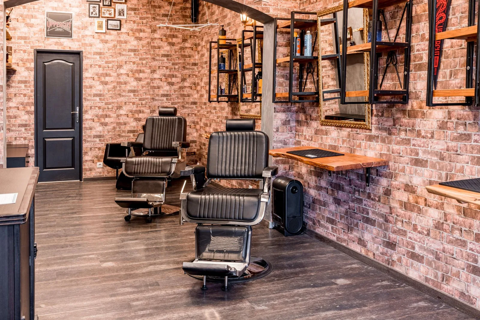 Empty barber chairs in a shop with brick walls