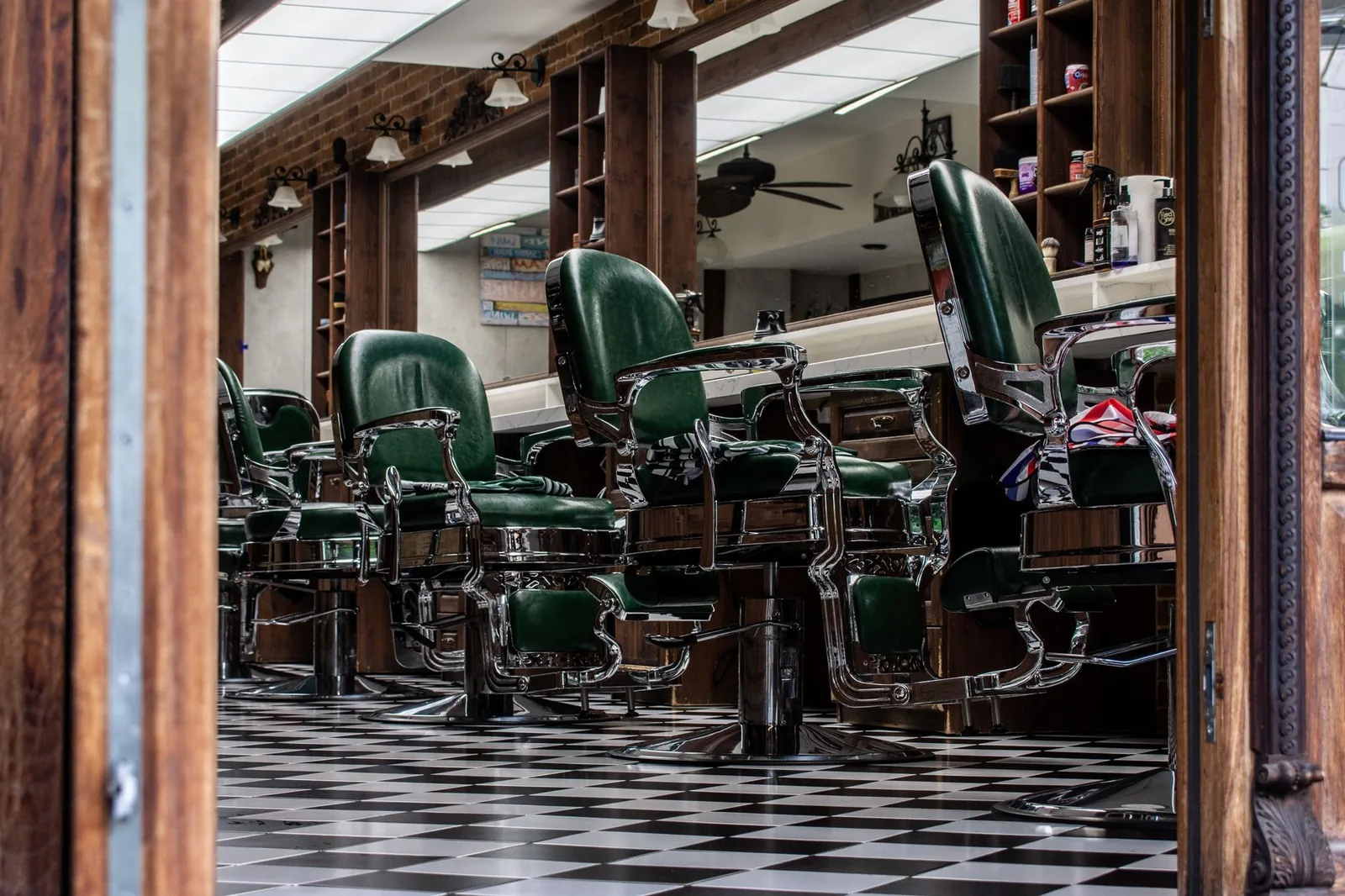 A vintage barbershop interior with classic chairs and a checkered tile floor.