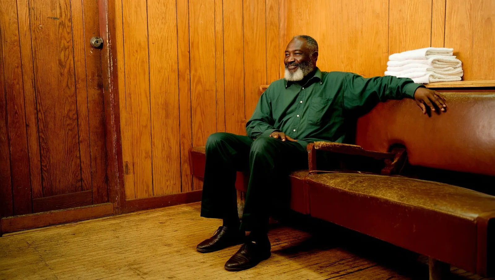 Man with a grey beard on a barbershop bench