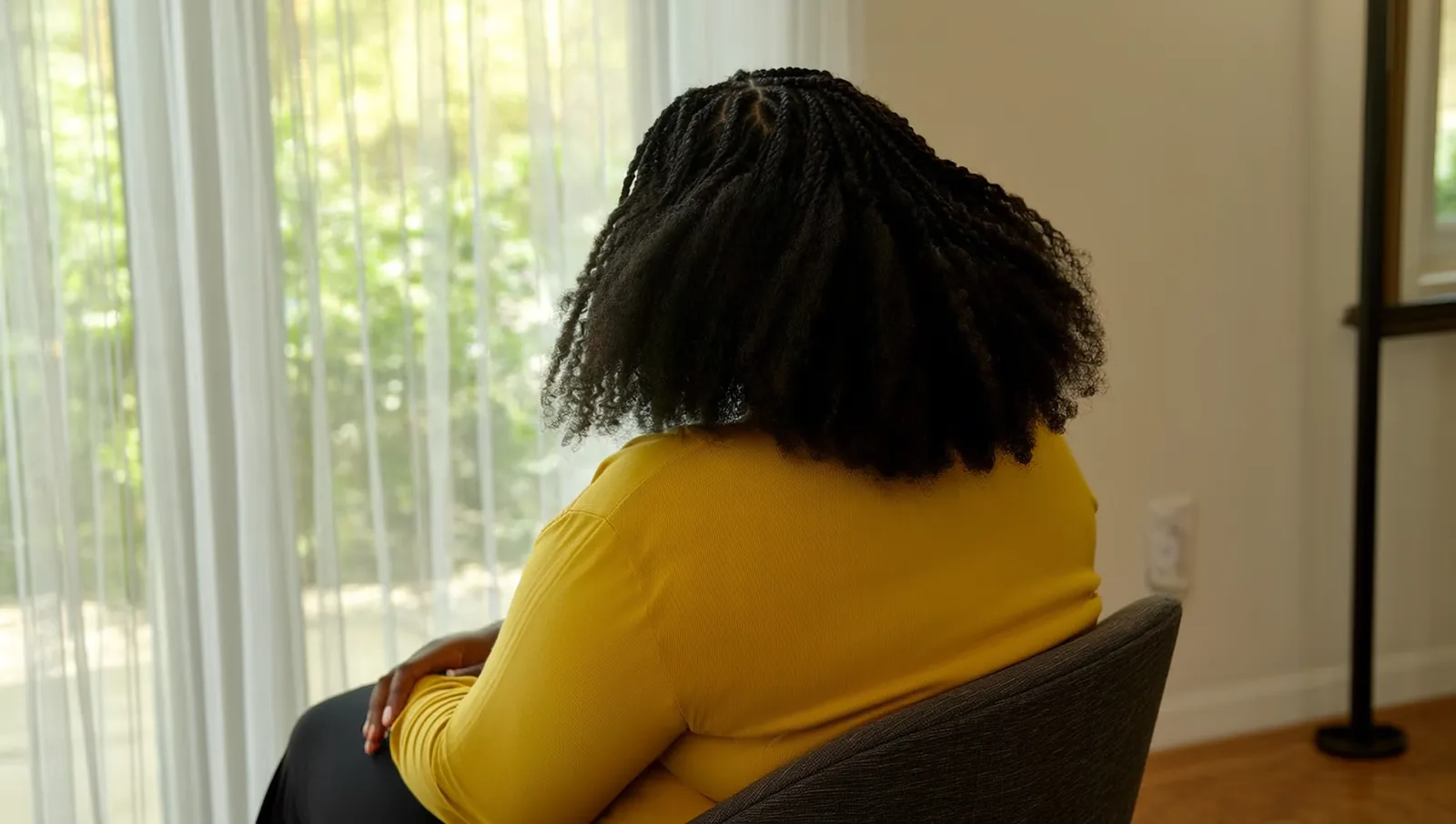Woman with loose natural twists by a window