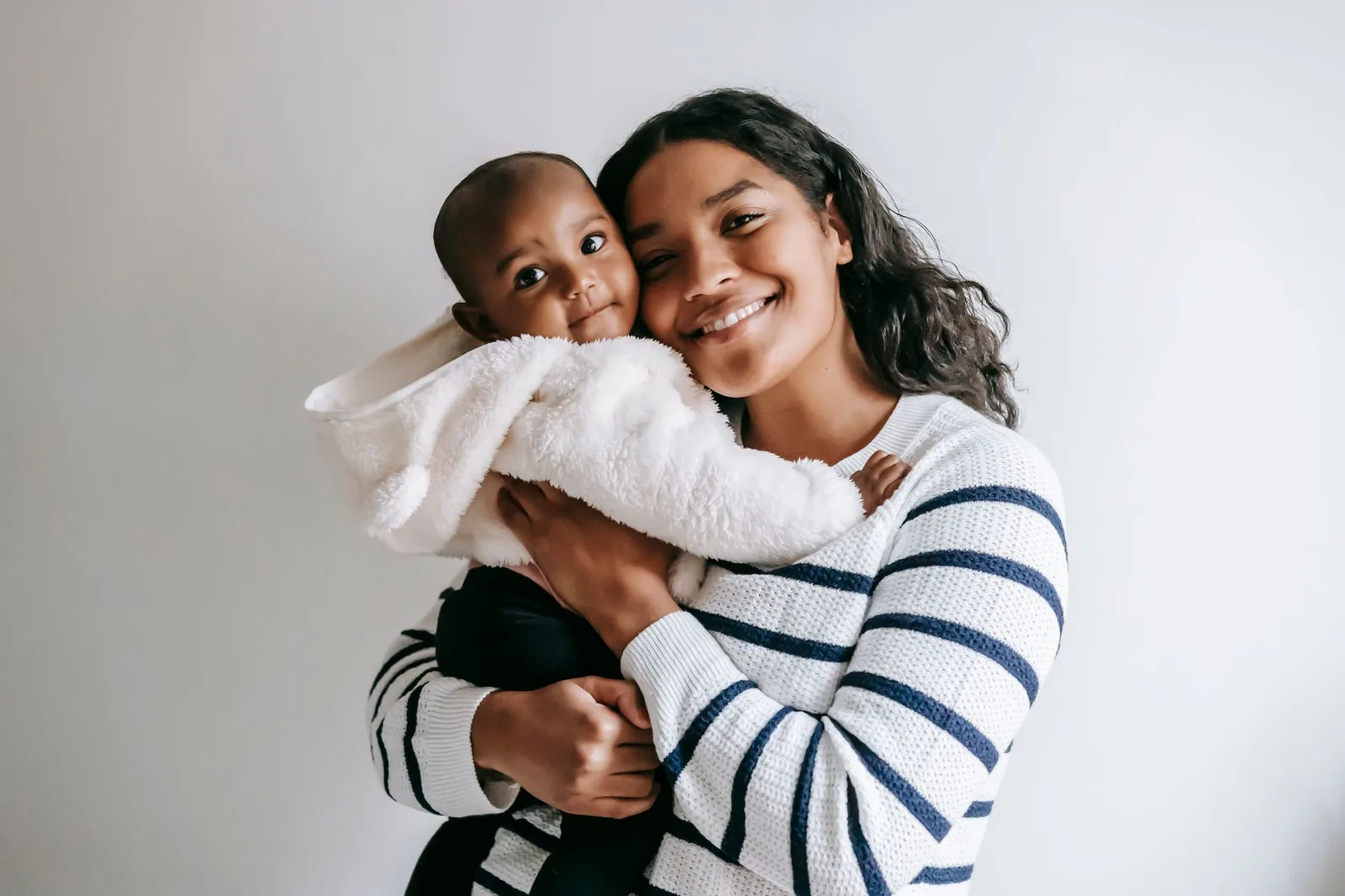 Black mother smiling while holding her baby