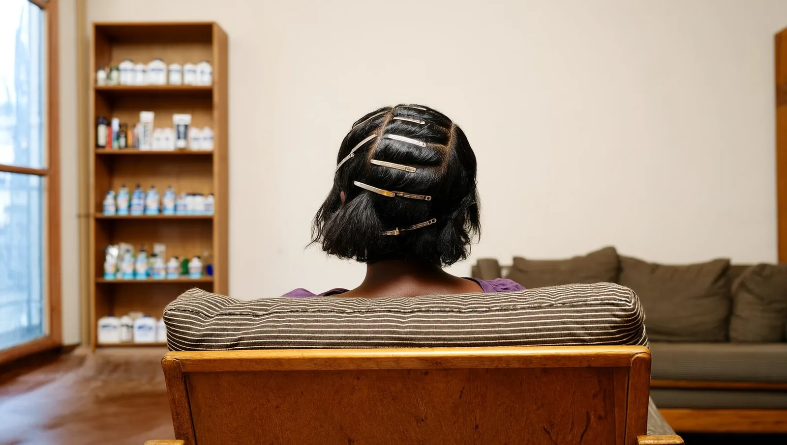 Back of a woman's head with her hair parted into clipped sections